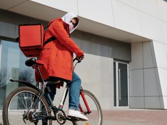 Delivery man with a face mask riding a bicycle