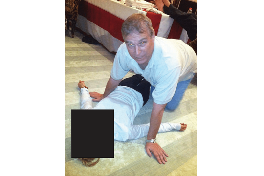 Andrew Mountbatten Windsor kneeling over woman